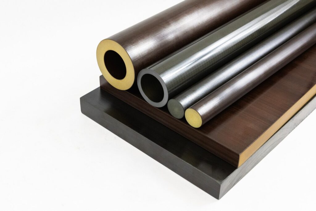 Torlon Seamless Tube shown alongside Torlon rod and plate stock shapes